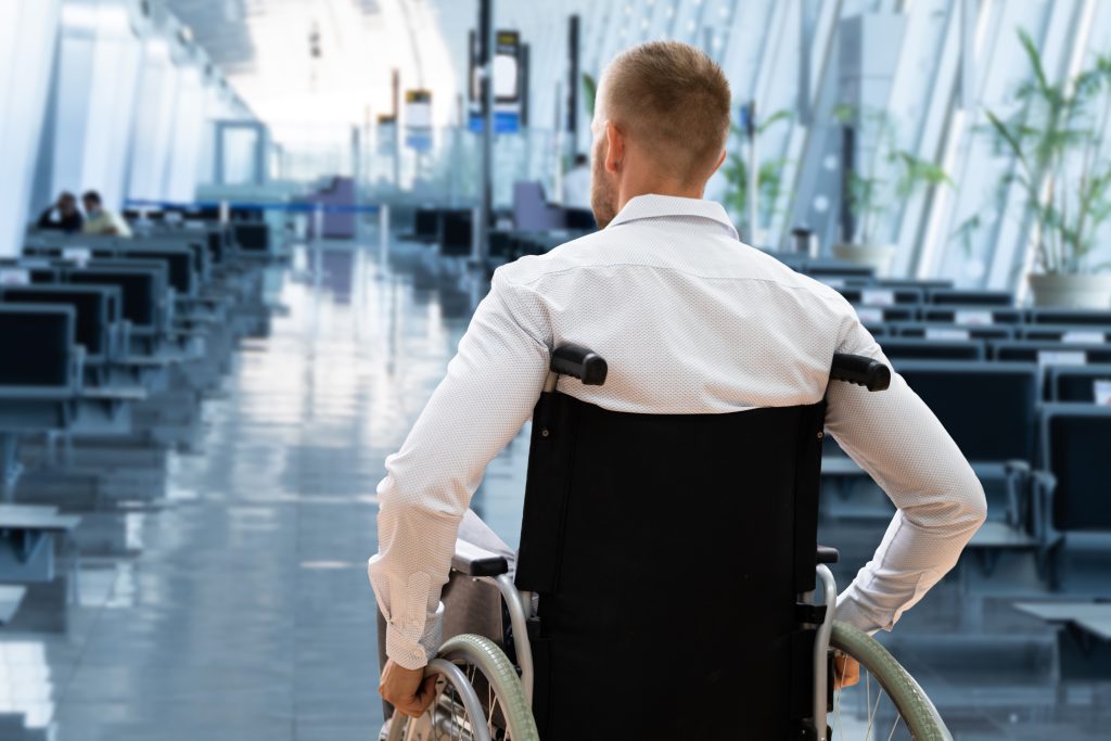 A wheelchair user in an airport aisle.